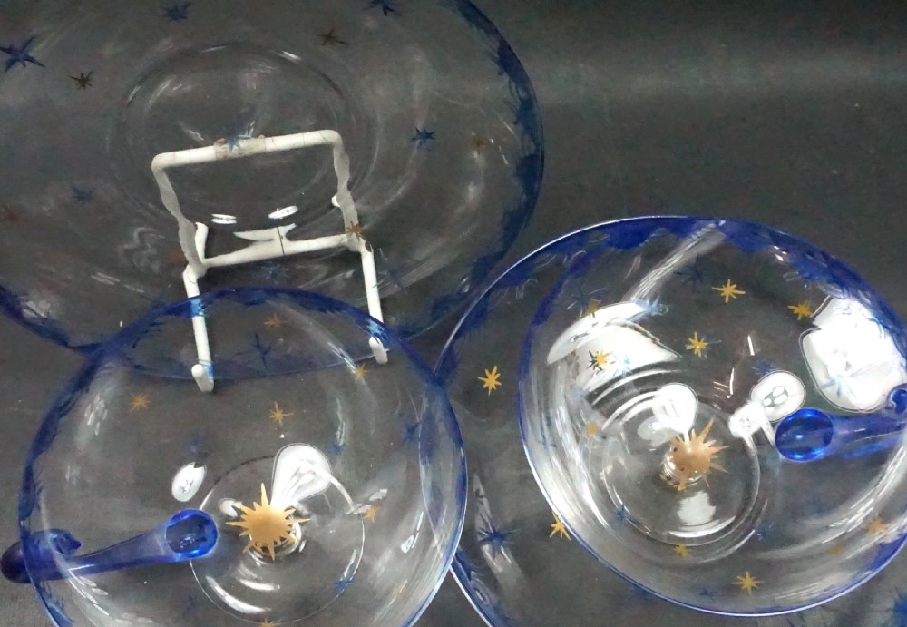 Pair of clear glass teacups and matching saucers featuring cobalt blue rim borders and painted gold star motifs. View II