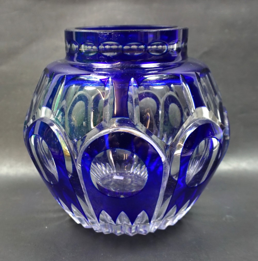 An Art Deco cobalt blue cut-to-clear crystal vase featuring circular lens cuttings and geometric facet detailing.