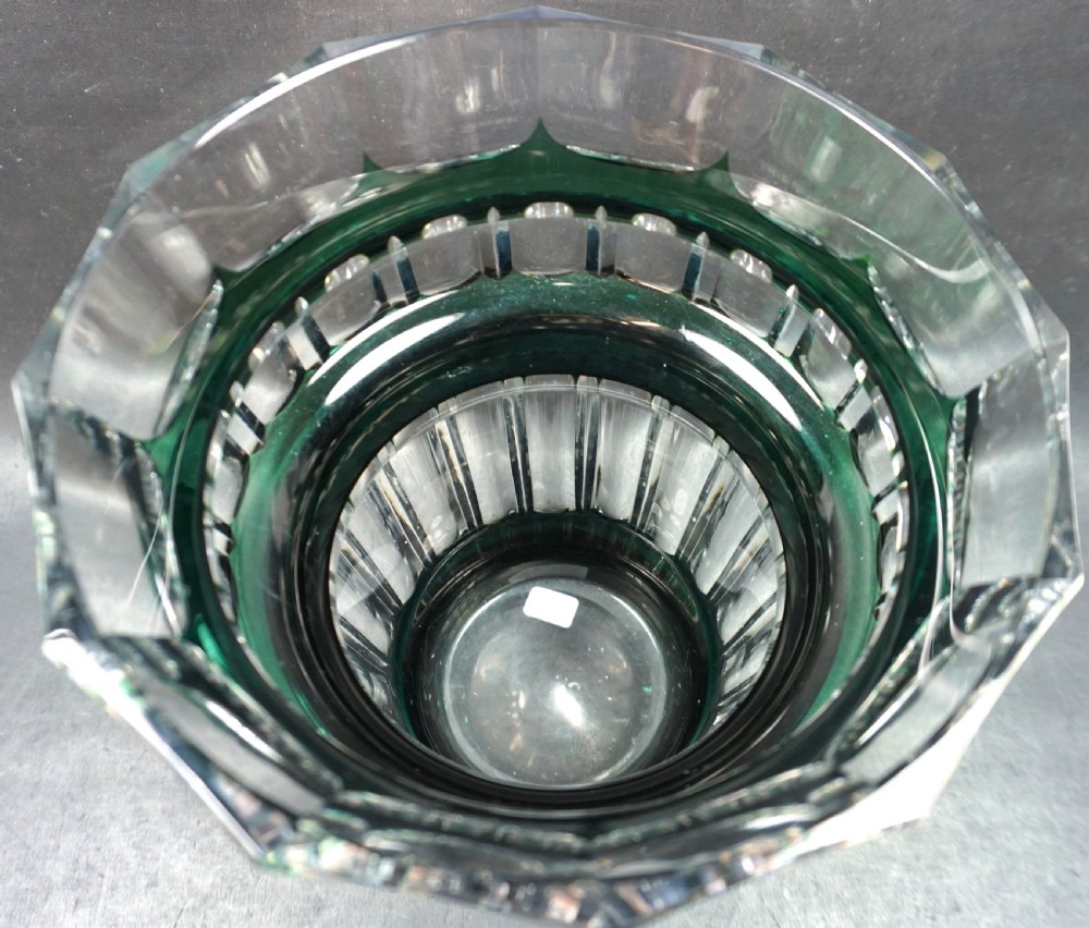 A heavy Art Deco glass vase featuring an emerald green overlay cut into geometric facets over clear lead crystal. View II