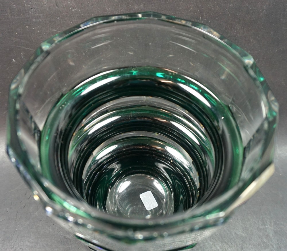 A heavy Art Deco crystal vase featuring a stepped, tiered geometric design in clear cut crystal and deep emerald green overlay glass. View II