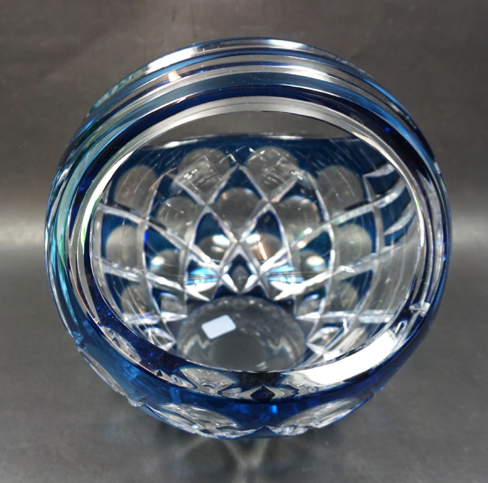 A circular cobalt blue and clear cut crystal glass basket featuring an integrated arched handle and geometric faceting. View II