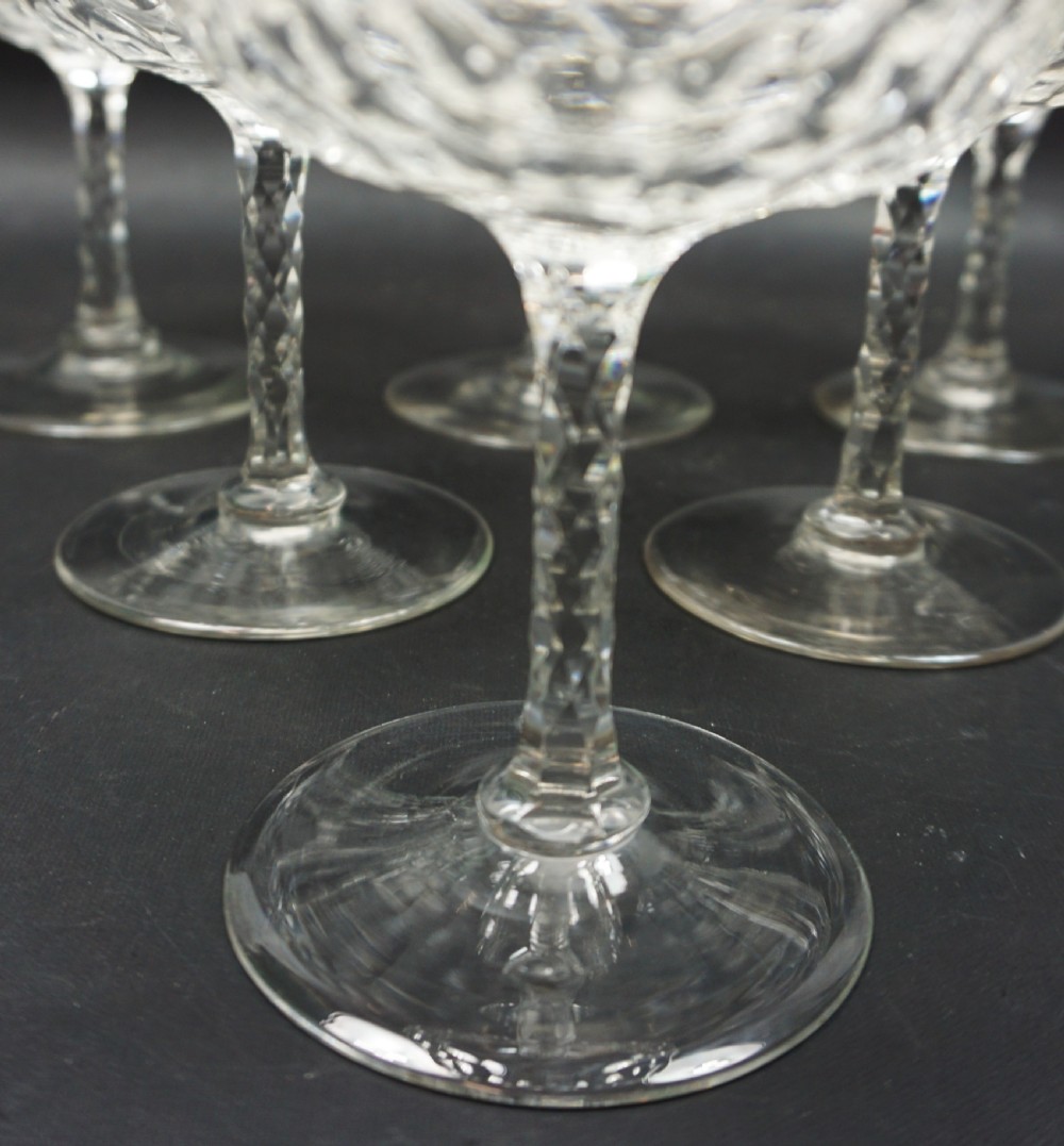 A set of six clear Victorian cut-crystal champagne coupes featuring shallow wide bowls and facet-cut stems. View II