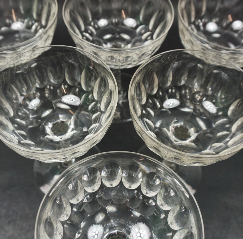 A set of six clear Victorian cut-crystal champagne coupes featuring shallow wide bowls and facet-cut stems. View III
