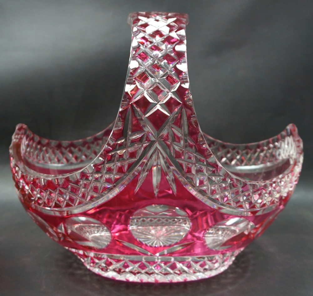 A pair of Art Deco ruby red cut-to-clear lead crystal glass baskets featuring geometric diamond facets and curved handles. View II