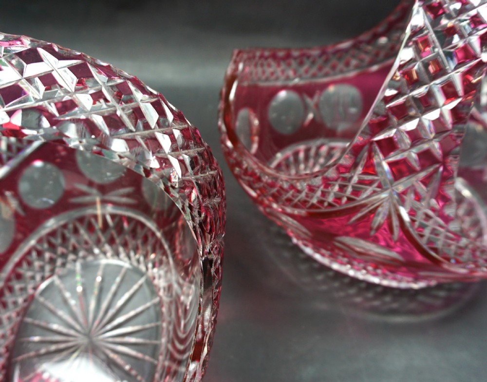 A pair of Art Deco ruby red cut-to-clear lead crystal glass baskets featuring geometric diamond facets and curved handles. View III