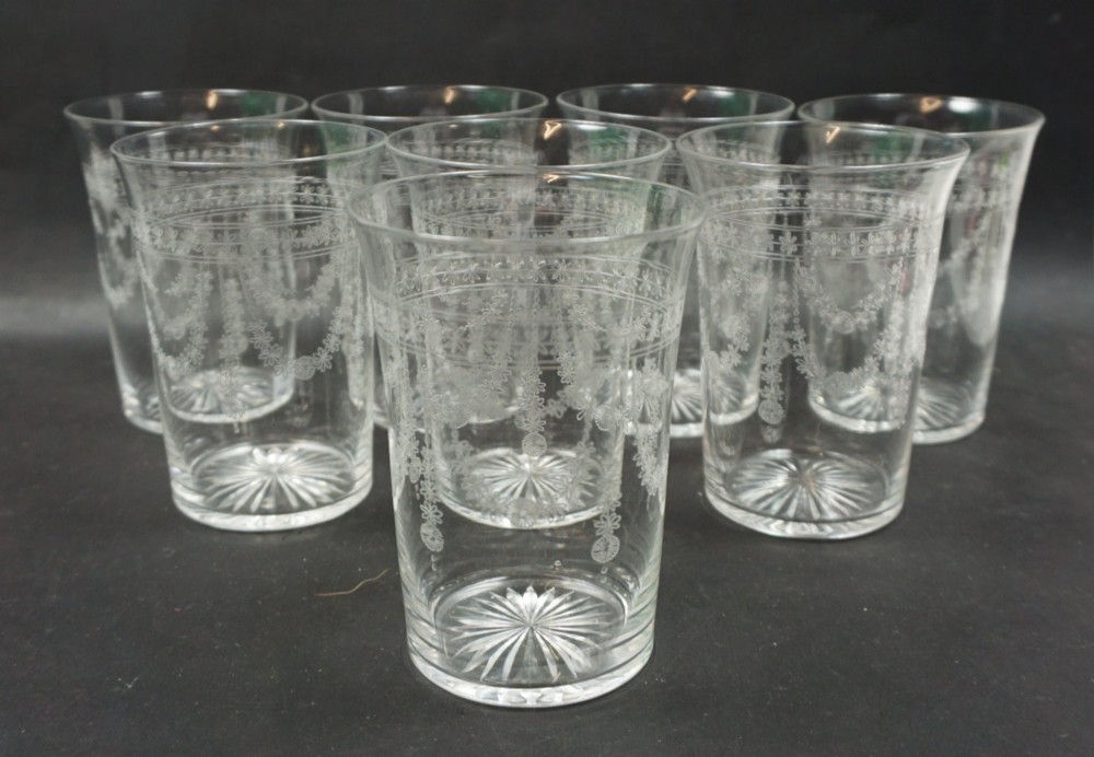 A set of eight clear crystal glass tumblers decorated with acid-etched floral festoons and starburst cut bases.