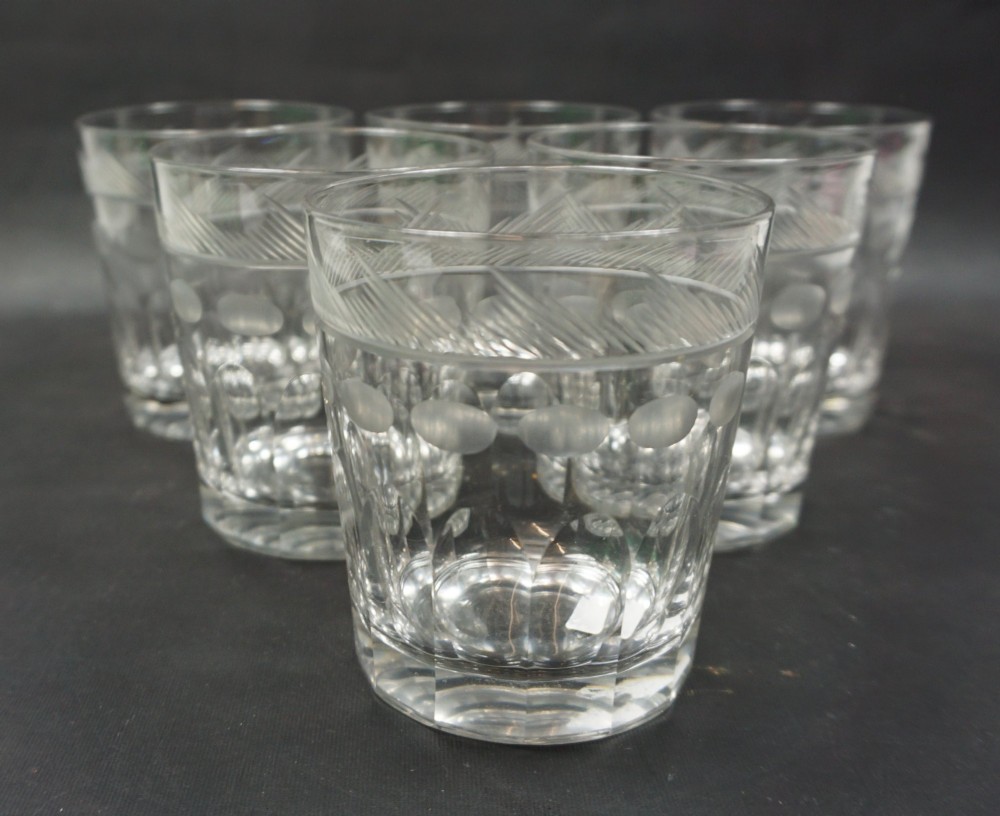 A set of six clear cut crystal glass tumblers featuring hatched rim bands, thumbprint motifs, and faceted bases.