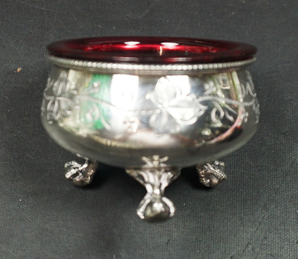 A pair of Victorian silver-plated open salt cellars with chased ivy leaf decoration and vibrant red cranberry glass liners. View III