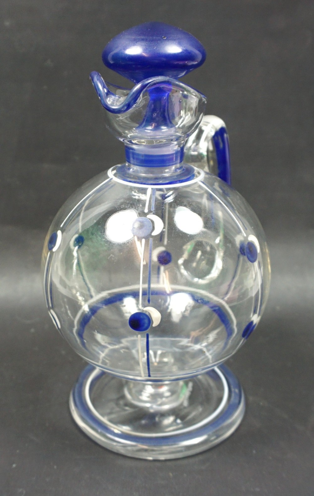 An Art Deco clear crystal glass wine jug featuring blue and white enamel geometric patterns, a clear handle, and a mushroom-shaped blue glass stopper. View II
