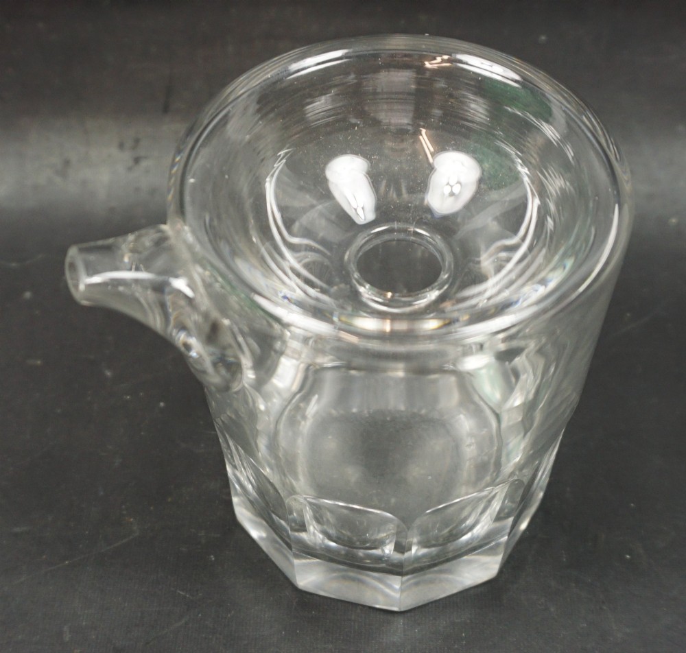 A clear heavy cut crystal glass feeding cup featuring an integrated spout and vertical flute cut detailing around the lower portion. View II