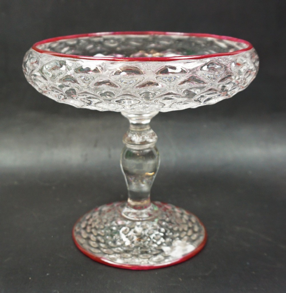 A honeycomb moulded crystal glass tazza with red cane decoration, English c.1880