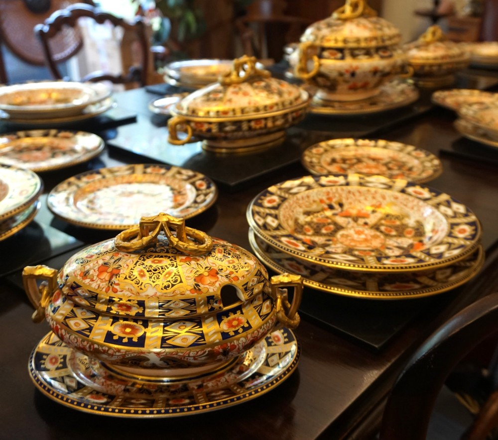 An extensive Victorian Davenport Imari pattern porcelain dinner service comprising numerous plates, serving platters, and covered tureens decorated in cobalt blue, orange, and gilt. View III