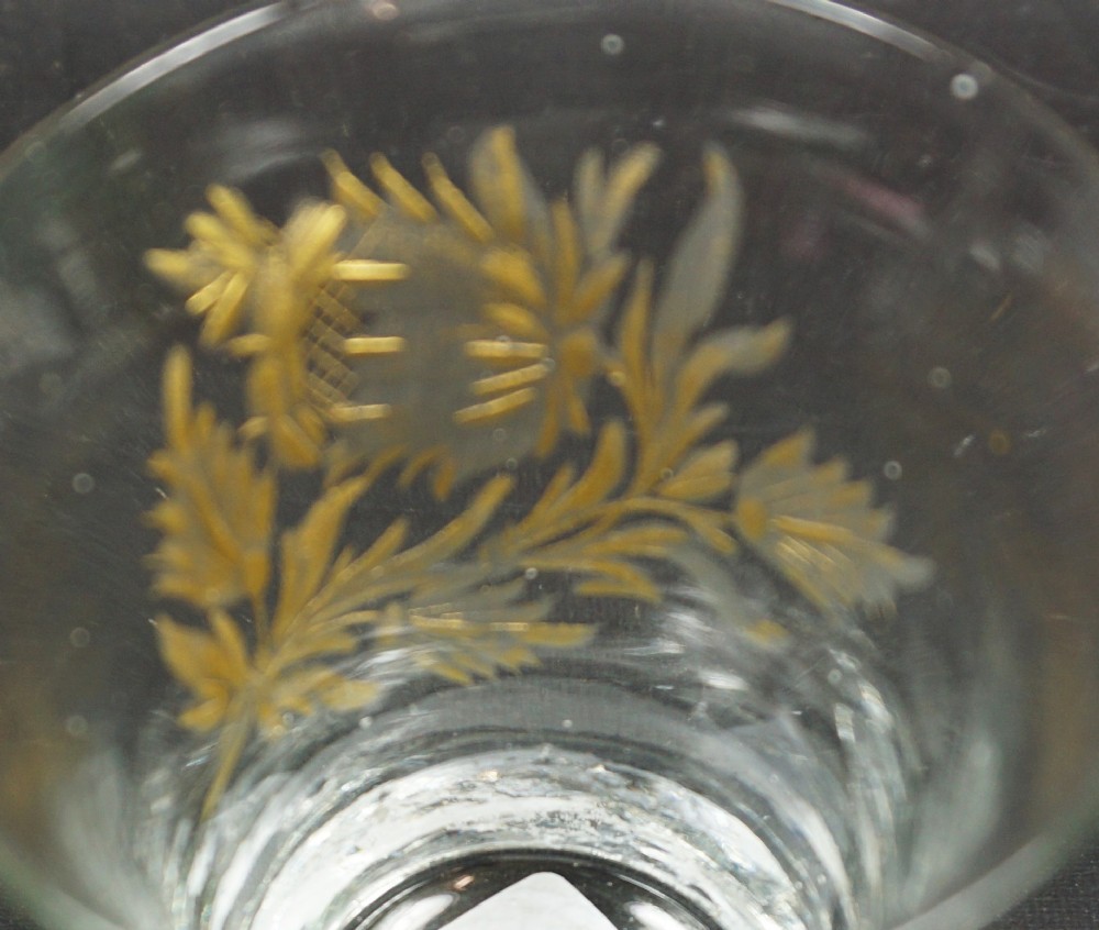 A small clear hand-blown glass tumbler featuring wheel-engraved floral motifs highlighted with gold leaf gilding. View II