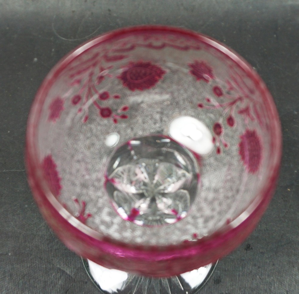 An acid-etched French lead crystal wine glass featuring a cranberry red foliate motif over a textured clear glass body on a slender stem with a starburst base. View II