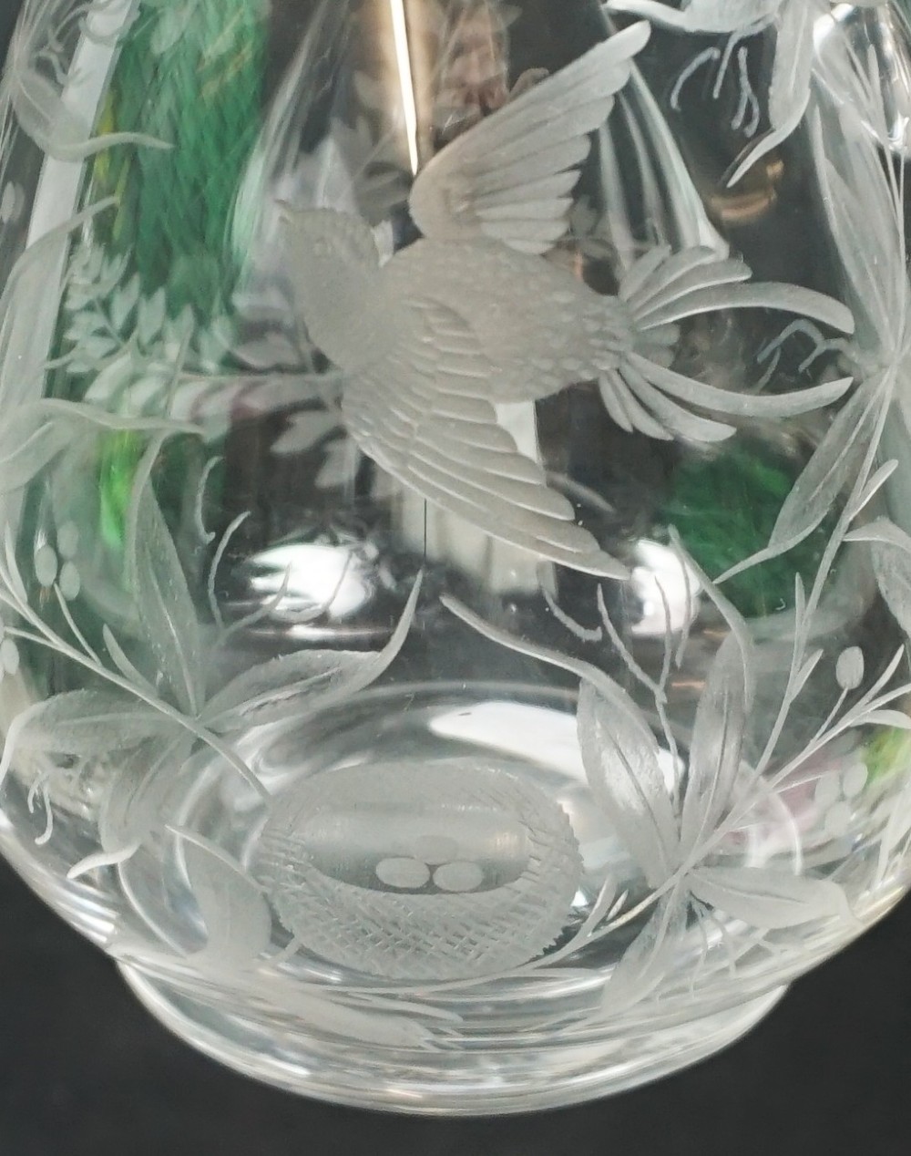 A clear glass jug featuring a single loop handle, flared rim, and detailed wheel-engraved motifs depicting a bird, nest with eggs, and foliage. View II