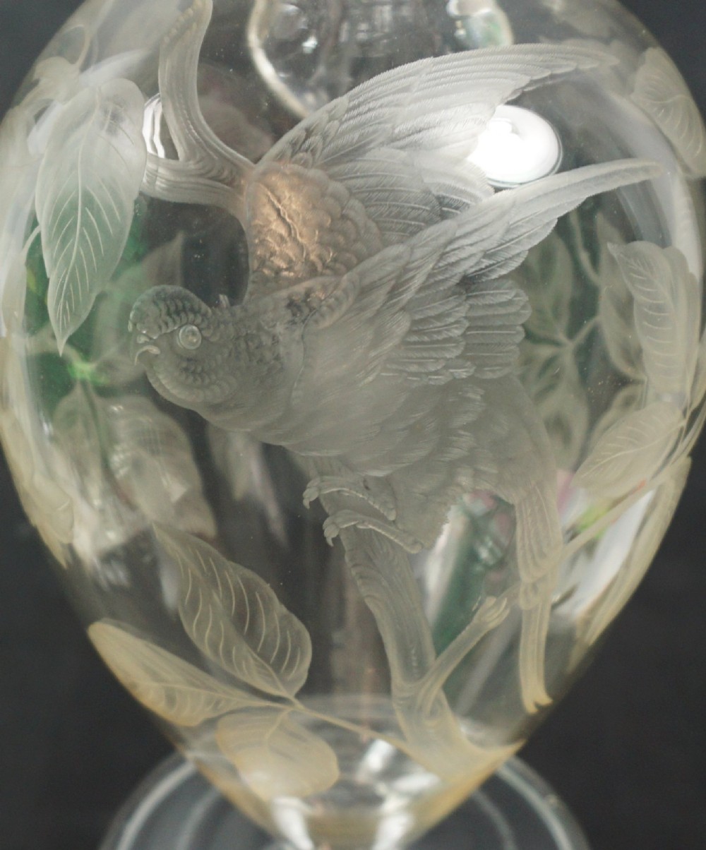 A late nineteenth-century clear lead crystal wine jug featuring wheel-engraved bird and leaf motifs, a flared rim, and a circular pedestal base. View II