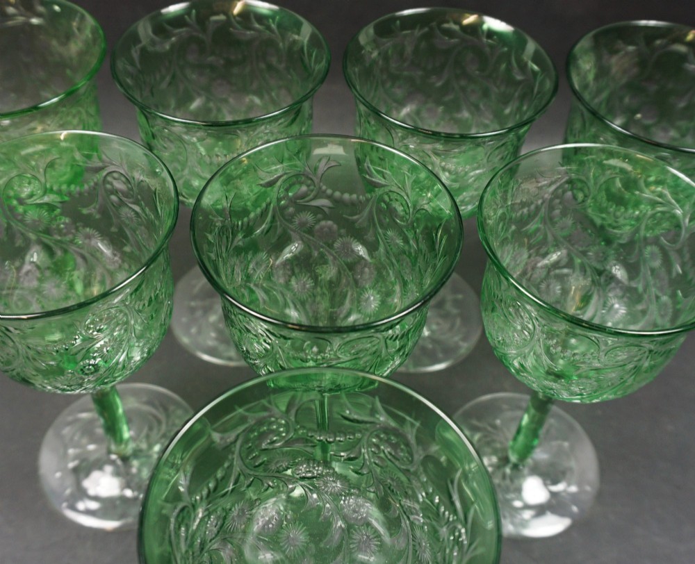 A set of eight green glass wine goblets featuring detailed intaglio engraved floral motifs and clear stemware bases. View II