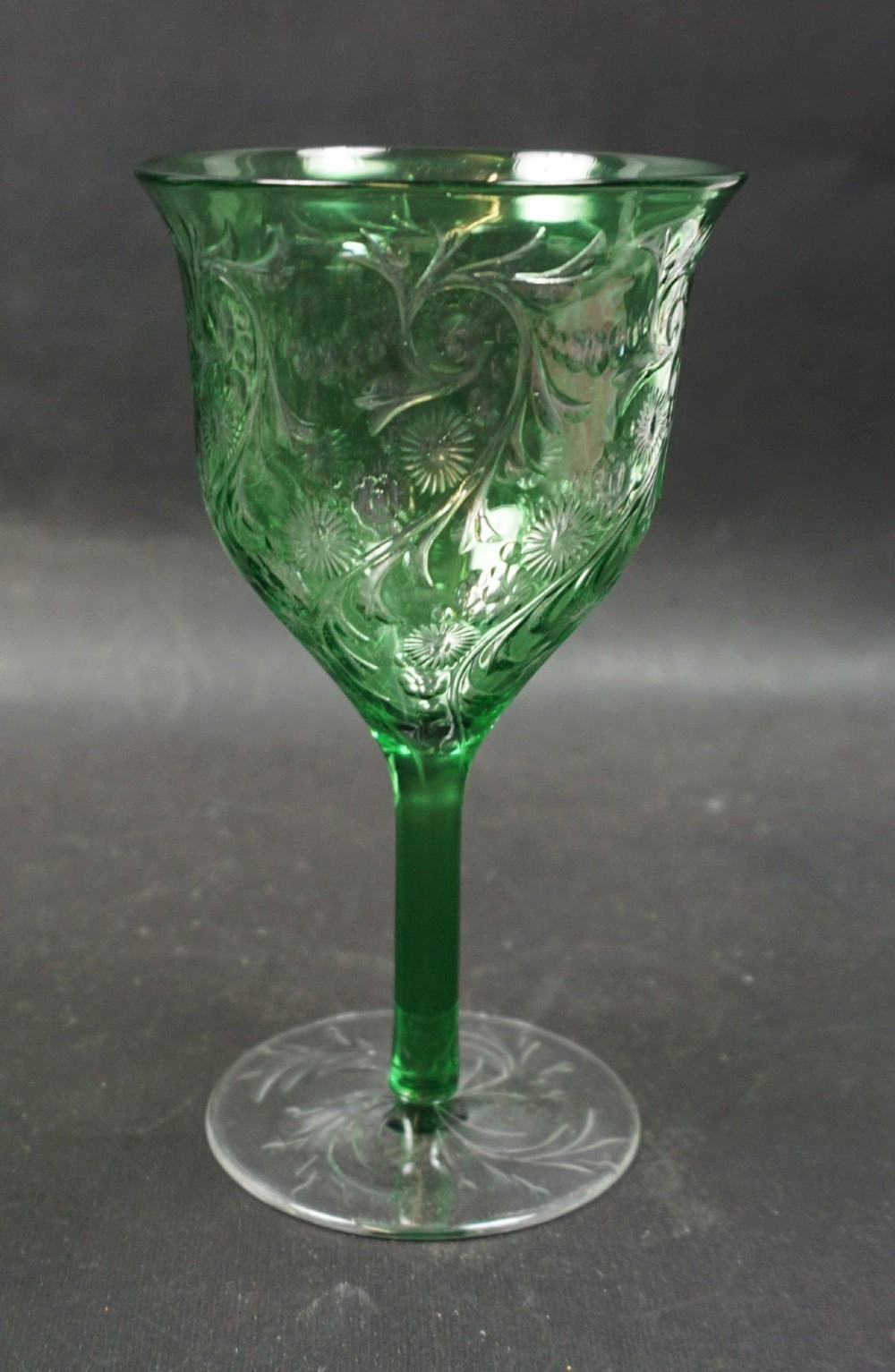 A set of eight green glass wine goblets featuring detailed intaglio engraved floral motifs and clear stemware bases. View III
