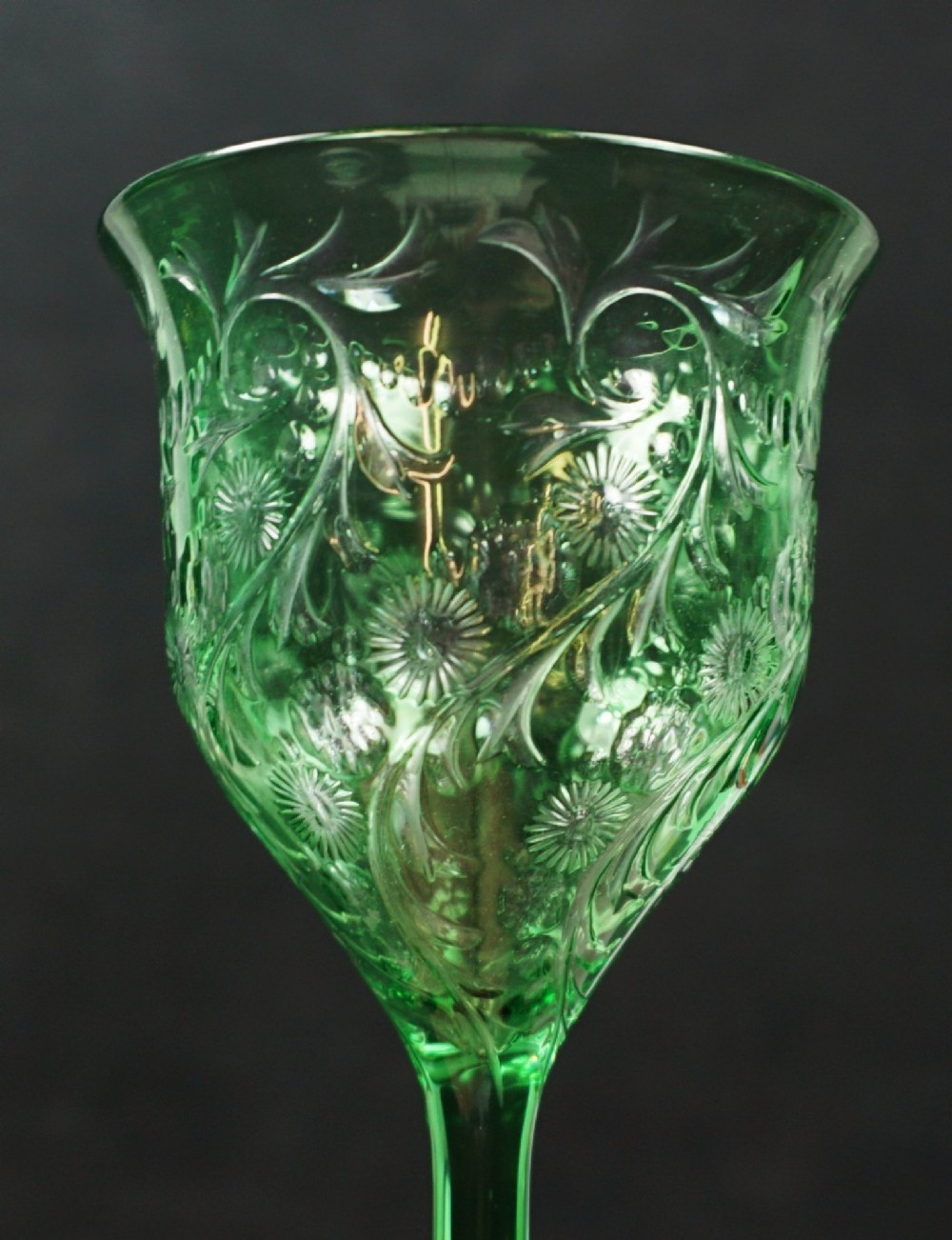 A set of eight green glass wine goblets featuring detailed intaglio engraved floral motifs and clear stemware bases. View IV
