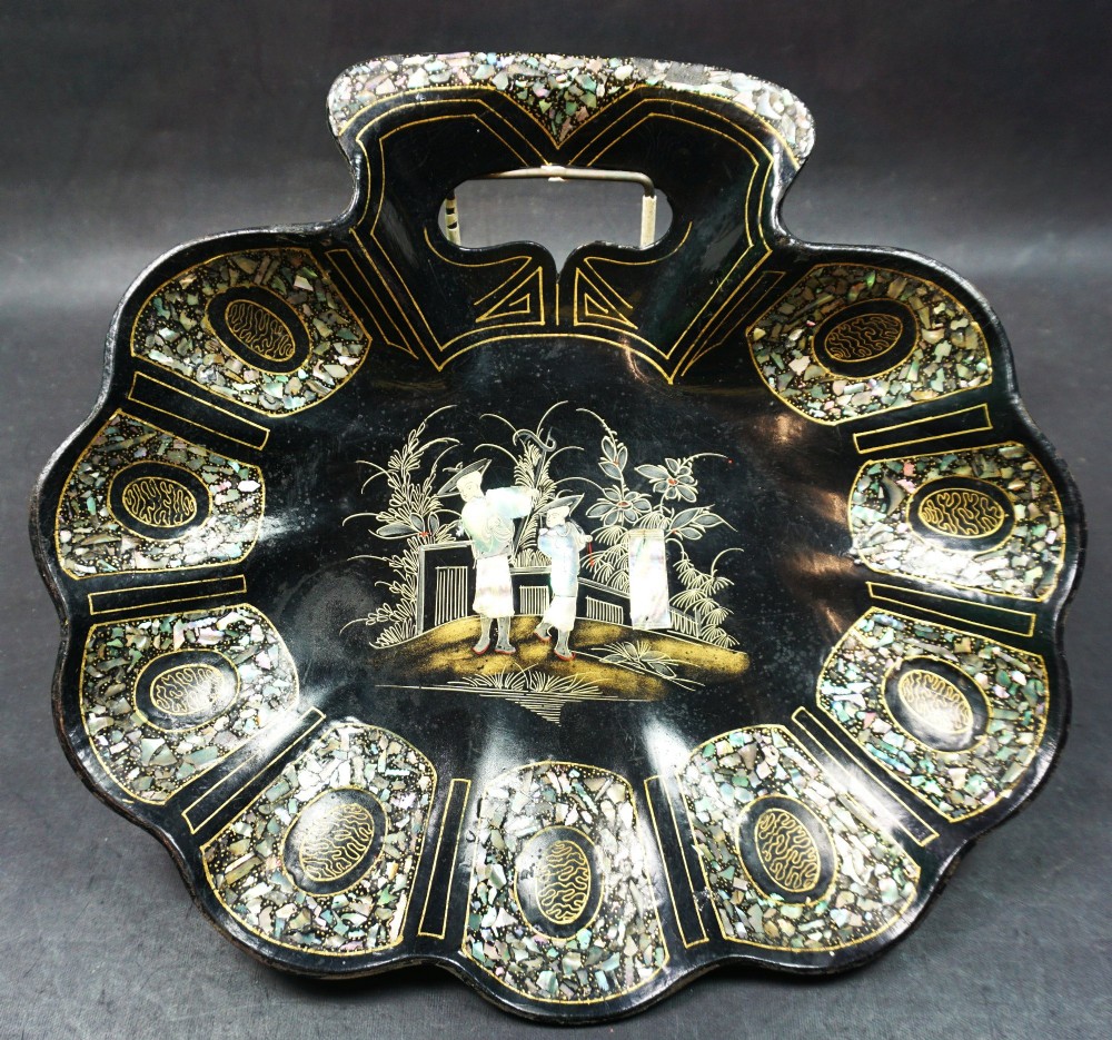A Victorian black lacquered papier-mache tray with a scalloped edge, detailed with mother-of-pearl inlay and gilded Chinoiserie figures.