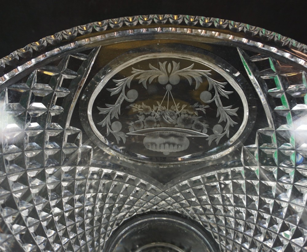 A clear cut lead crystal oval vase with wheel-engraved floral cartouches, diamond facet cutting, a scalloped rim, and a starburst circular foot. View II