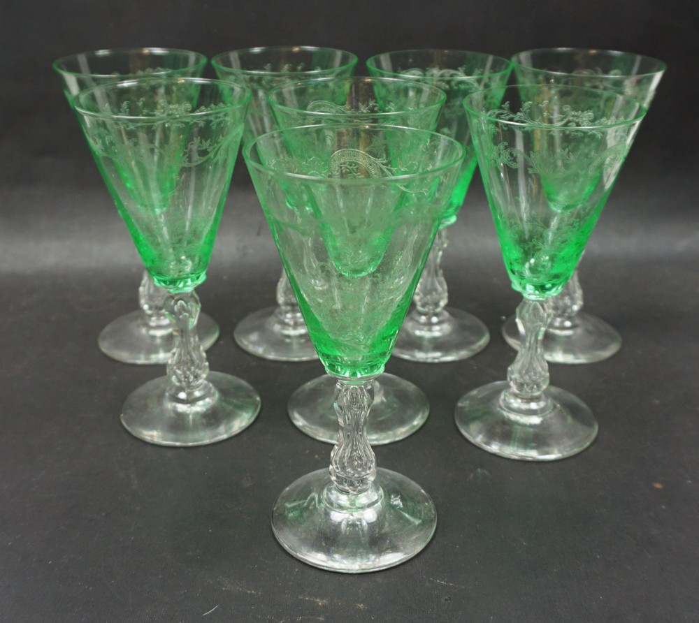 A set of eight French St. Louis green uranium glass wine goblets with etched Mikado patterns and clear stems.