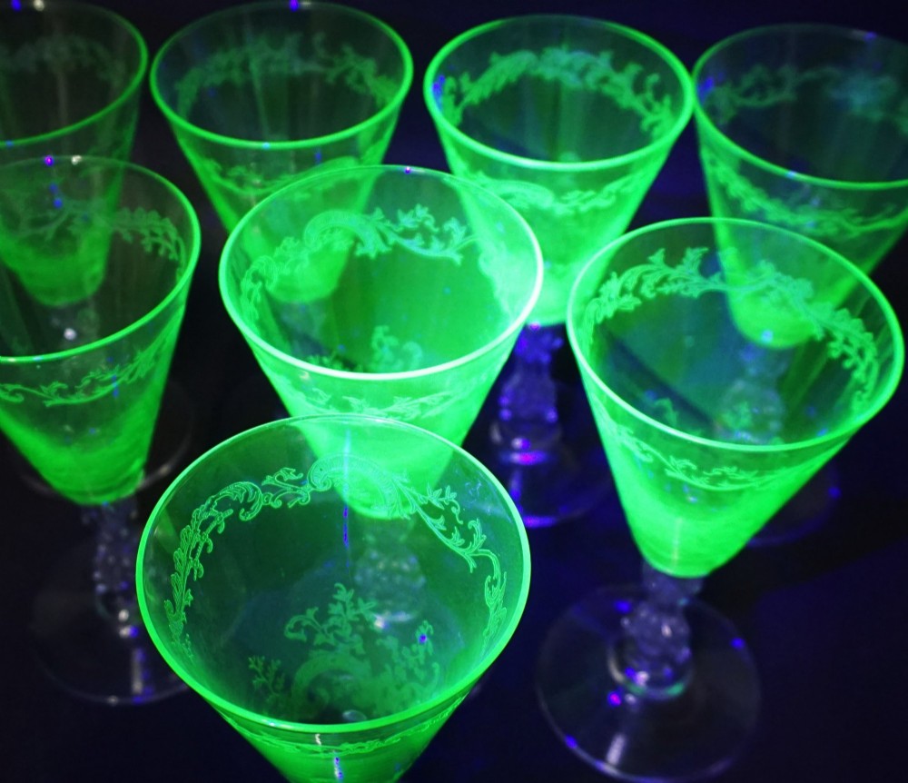 A set of eight French St. Louis green uranium glass wine goblets with etched Mikado patterns and clear stems. View III