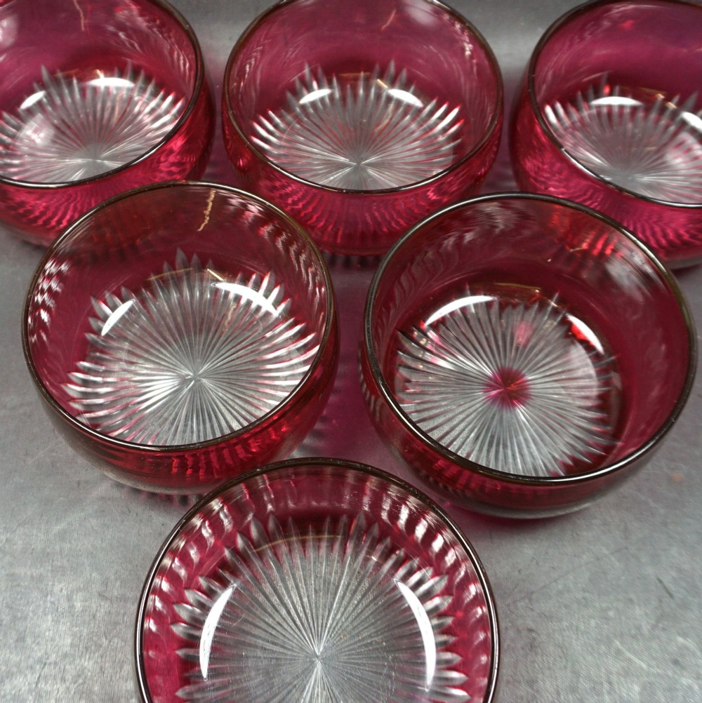 A set of six Victorian red overlay crystal glass finger bowls featuring cut starburst patterns on the bases. View II