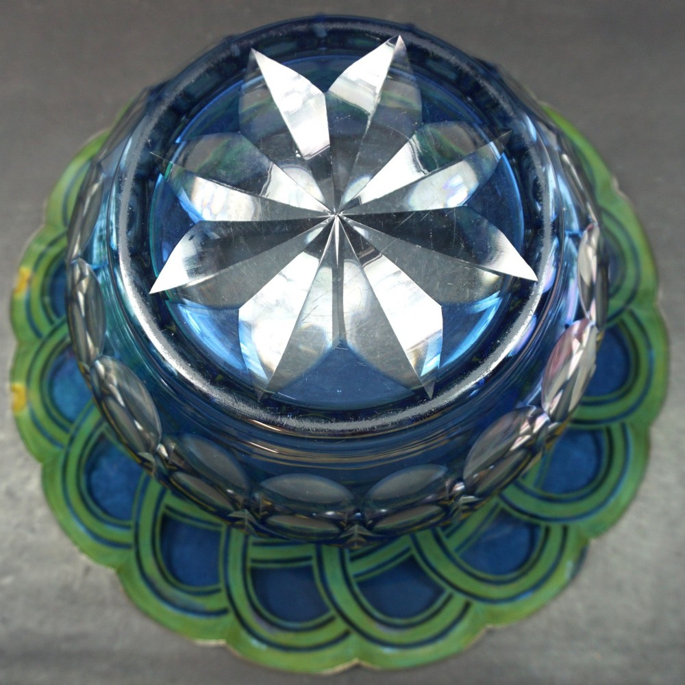 A cobalt blue cut crystal bowl featuring a flared scalloped rim decorated with geometric silver overlay arches and circular lens cuts around the lower body. View III