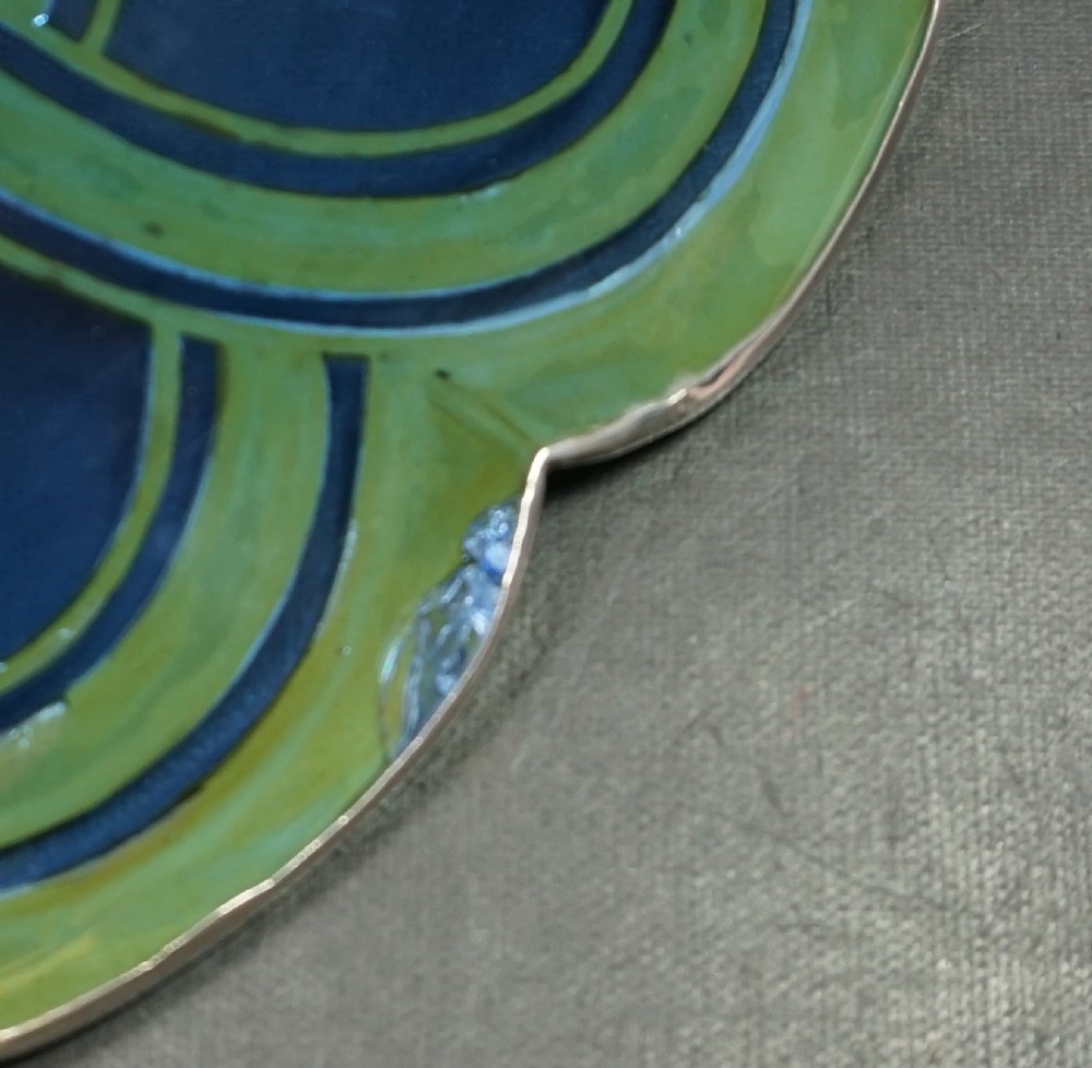A cobalt blue cut crystal bowl featuring a flared scalloped rim decorated with geometric silver overlay arches and circular lens cuts around the lower body. View V