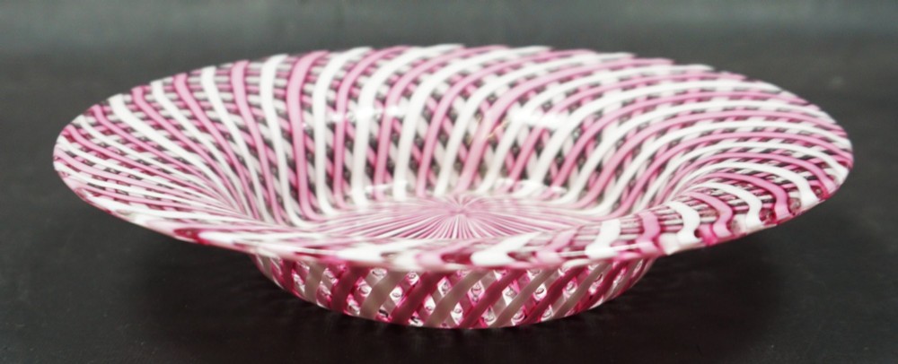 A circular Victorian glass plate featuring an intricate spiral lattice pattern formed from alternating pink and white opaque canes. View II