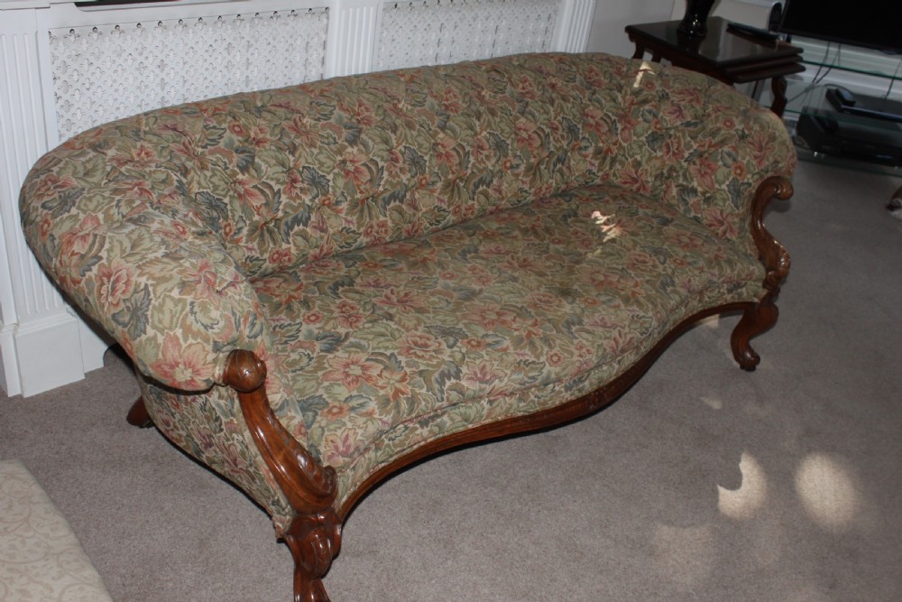 A Victorian carved walnut settee featuring button-tufted floral tapestry upholstery and scrolled wooden legs. View XII