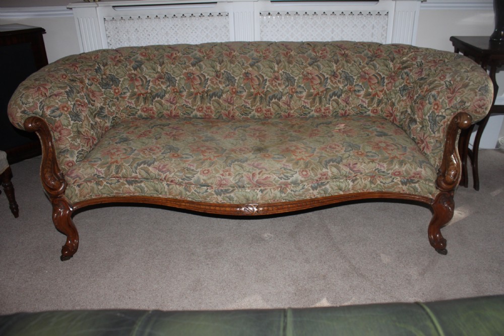 A Victorian carved walnut settee featuring button-tufted floral tapestry upholstery and scrolled wooden legs. View XIII