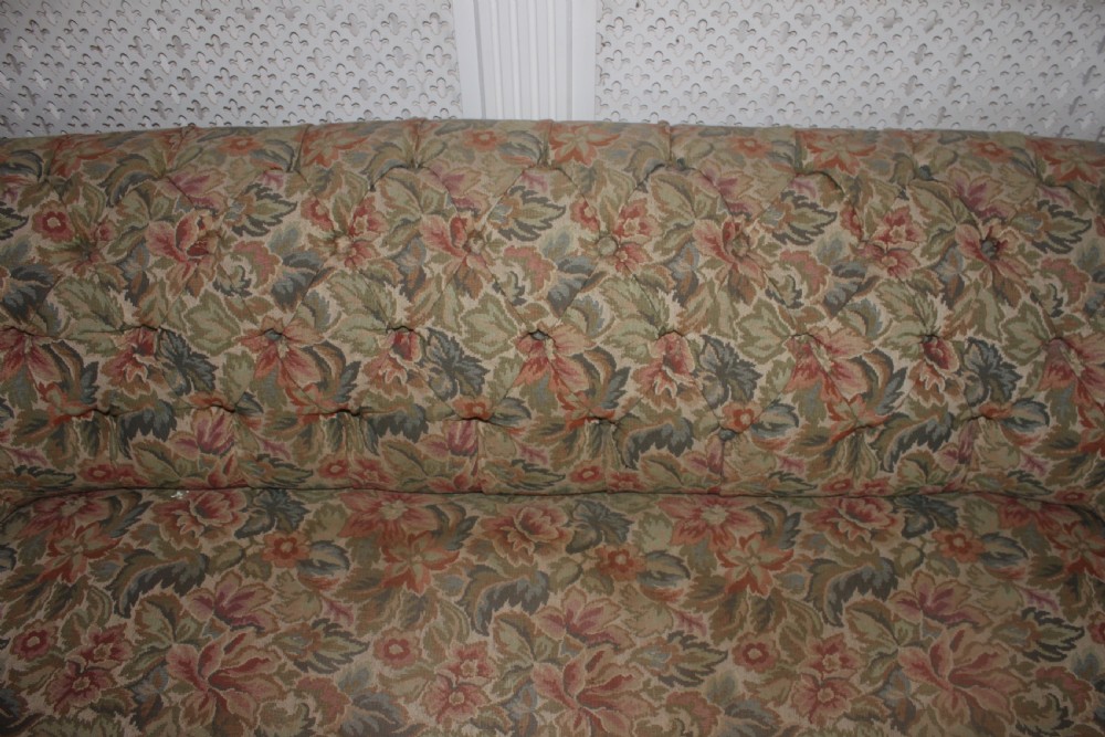 A Victorian carved walnut settee featuring button-tufted floral tapestry upholstery and scrolled wooden legs. View XVI