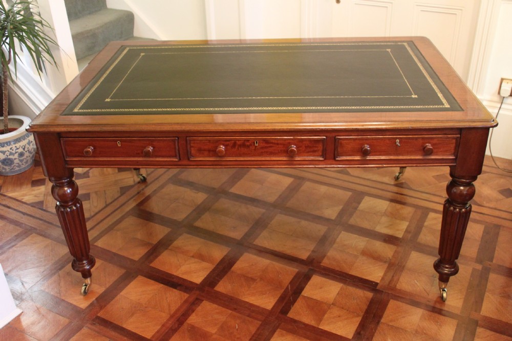 An early 19th century light mahogany six drawer partners library table