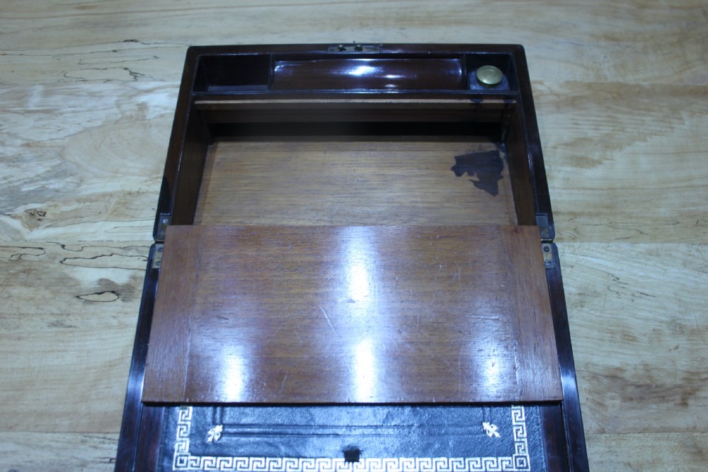 A rectangular dark rosewood writing slope box featuring a central brass cartouche and key inserted in the front lock. View XIII