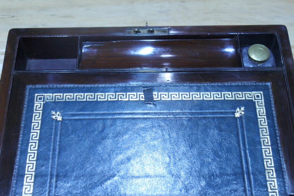 A rectangular dark rosewood writing slope box featuring a central brass cartouche and key inserted in the front lock. View XIV
