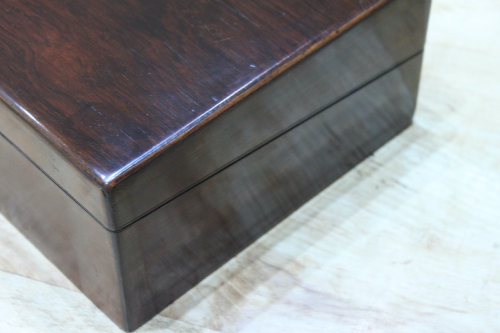A rectangular dark rosewood writing slope box featuring a central brass cartouche and key inserted in the front lock. View XVIII