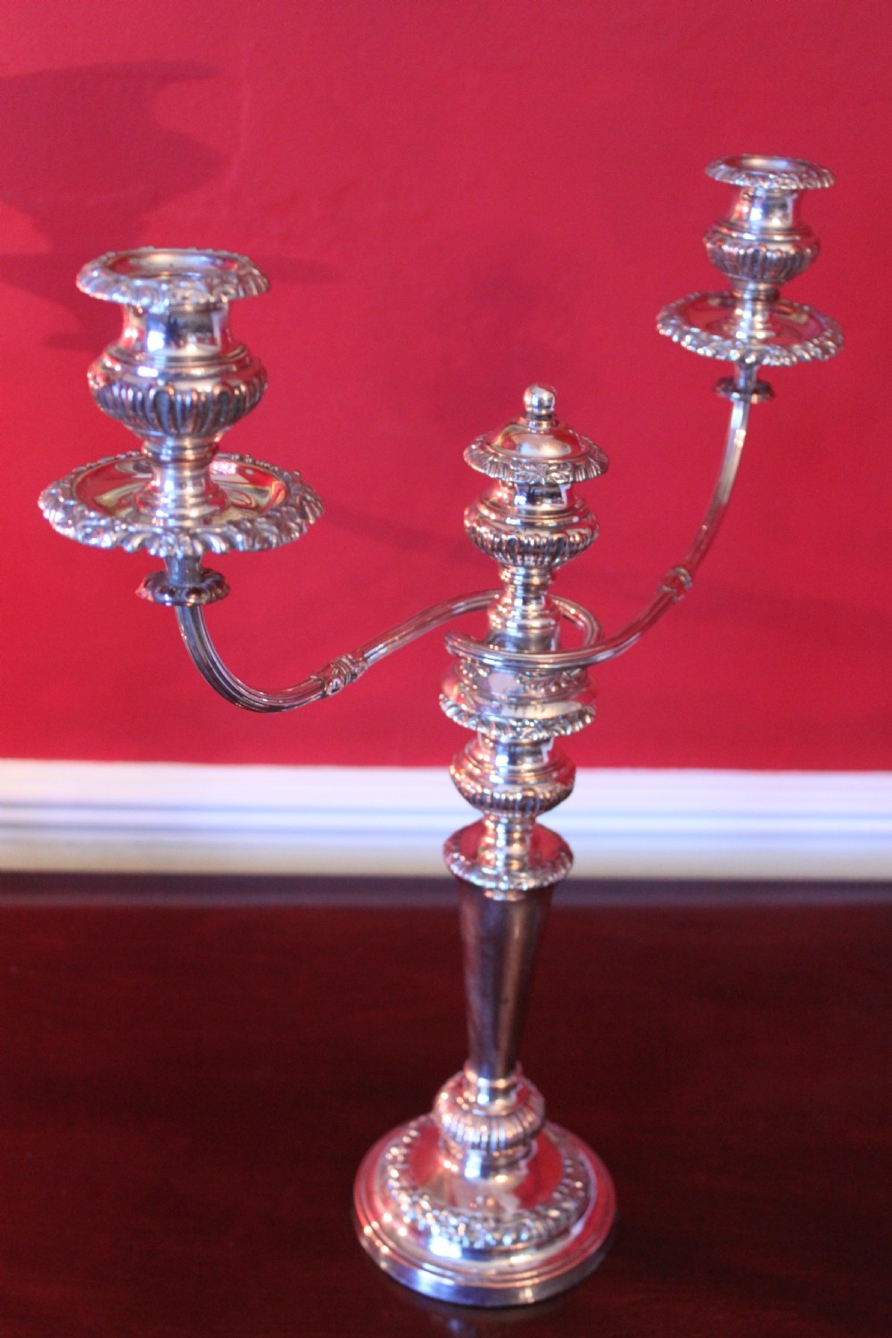 A pair of silver-plated three-light candelabra featuring classical turned column stems, gadrooned borders, and twin curved branches. View V