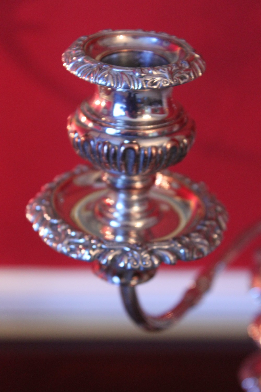 A pair of silver-plated three-light candelabra featuring classical turned column stems, gadrooned borders, and twin curved branches. View VI