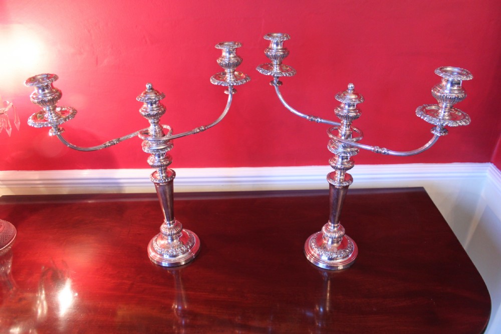 A pair of silver-plated three-light candelabra featuring classical turned column stems, gadrooned borders, and twin curved branches. View XII