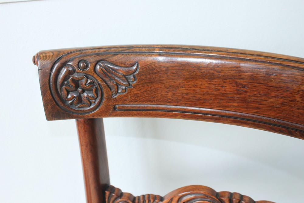 A set of six dark mahogany Regency dining chairs featuring carved top rails, reeded front legs, and cream striped fabric seats. View IV