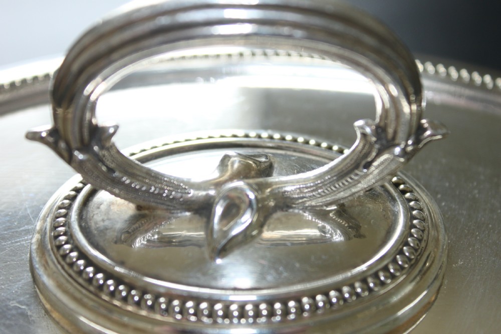 An oval Edwardian silver-plated entree dish featuring a beaded border and a central loop handle. View II