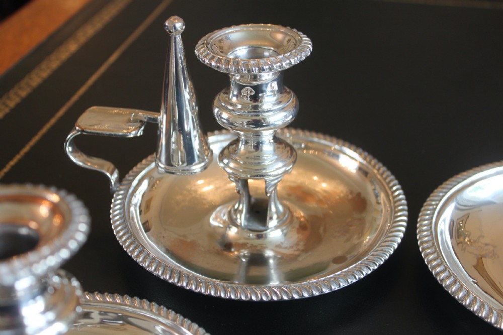 A set of four early nineteenth-century silver-plated chambersticks with circular drip pans, gadrooned rims, curved handles, and conical extinguishing snuffers. View VIII