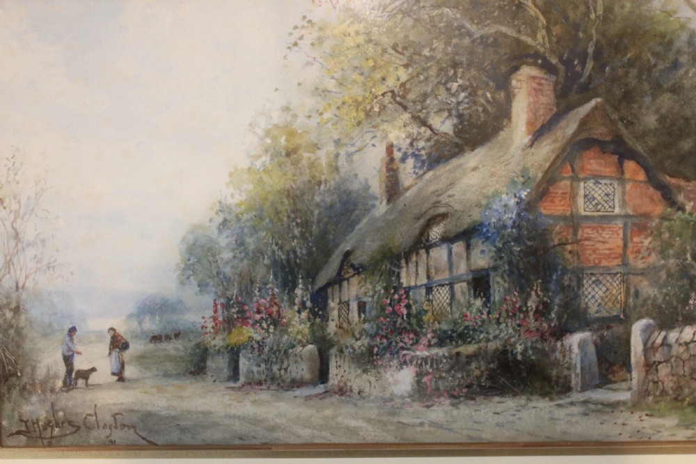 A framed watercolour painting depicting a thatched cottage alongside a country lane with figures, housed within a cream mount and an ornate swept gold frame. View III