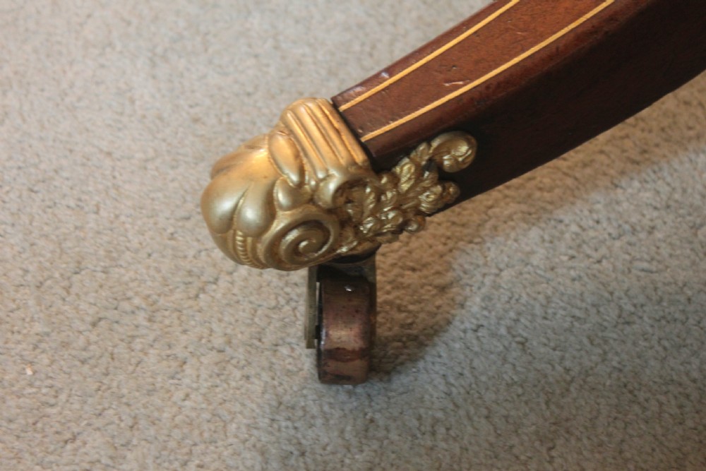 A dark mahogany Regency Pembroke table featuring brass line inlay, a single end drawer, drop leaves, and quadform sabre legs with brass cap castors. View V