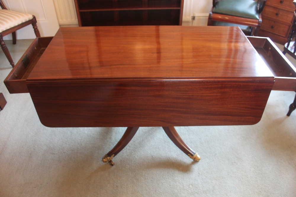 A dark mahogany Regency Pembroke table featuring brass line inlay, a single end drawer, drop leaves, and quadform sabre legs with brass cap castors. View VII