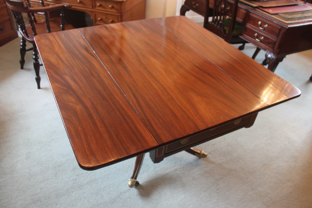 A dark mahogany Regency Pembroke table featuring brass line inlay, a single end drawer, drop leaves, and quadform sabre legs with brass cap castors. View IX