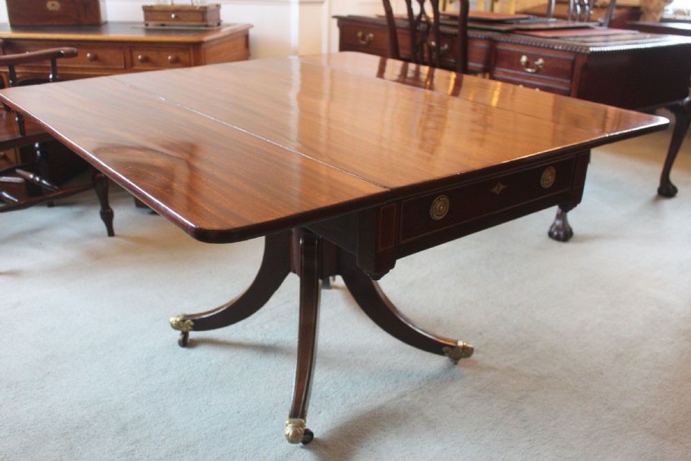 A dark mahogany Regency Pembroke table featuring brass line inlay, a single end drawer, drop leaves, and quadform sabre legs with brass cap castors. View X