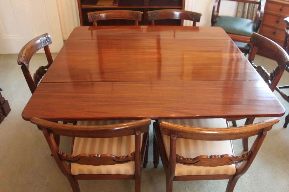 A dark mahogany Regency Pembroke table featuring brass line inlay, a single end drawer, drop leaves, and quadform sabre legs with brass cap castors. View XIII